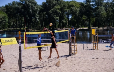 X-Park in Kyiv - active game of beach volleyball on a sandy court near the water