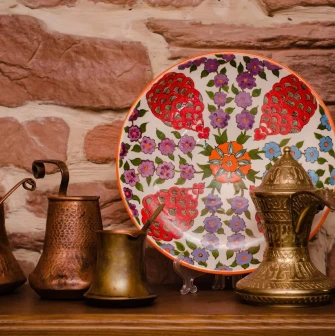 Sofra in Kyiv - decor composition with copper coffee pots and painted ceramic plate