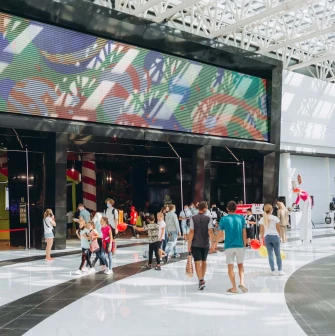 Скляні вітрини магазинів із вивісками у широкому коридорі Blockbuster Mall