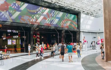 Скляні вітрини магазинів із вивісками у широкому коридорі Blockbuster Mall