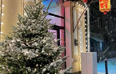 Restaurant Kytaiskyi Pryvit - restaurant entrance decorated with a snowy fir tree and lanterns