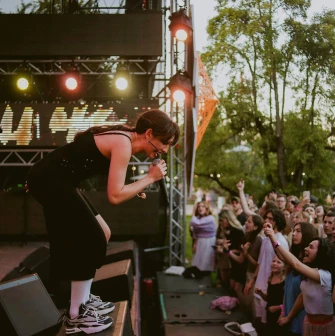 Vyava in Kyiv - singer in black leaning into a microphone in front of a crowd