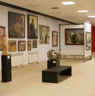 Muzei Suchasnoho Mystetstva in Kyiv - spacious and well-lit main gallery corridor filled with diverse paintings and small sculptures on pedestals
