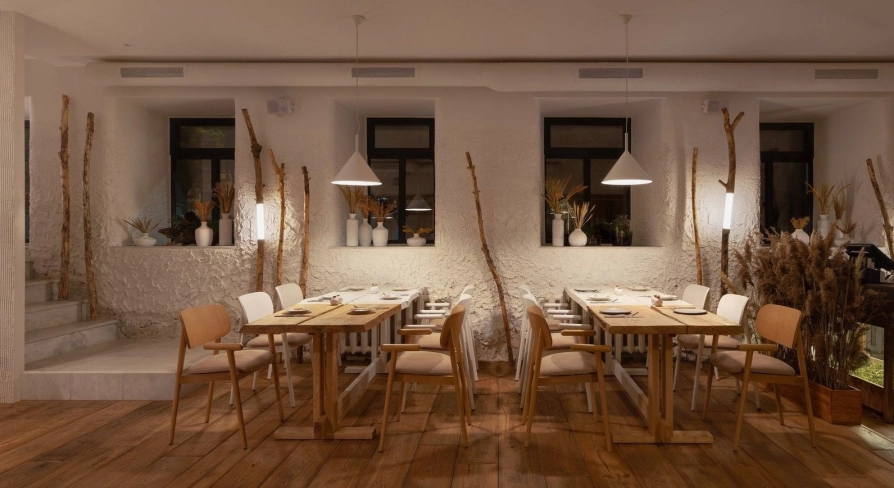 Restaurant 100 Rokiv Tomu Vpered - cozy tables near white textured walls and dark windows