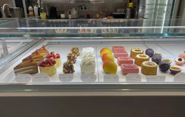 Honey in Kyiv - display case showcasing colorful mousse cakes and fruit desserts