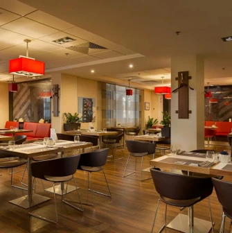 Ibis Kyiv City Center in Kyiv - dining hall with wooden tables and red lamps