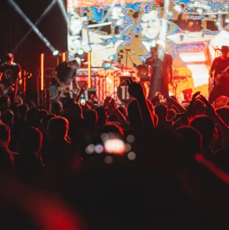 Atlas in Kyiv - dark silhouettes of the crowd raising hands before the bright stage with a performing rock band