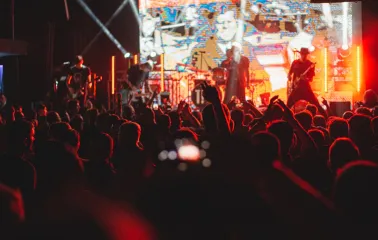 Atlas in Kyiv - dark silhouettes of the crowd raising hands before the bright stage with a performing rock band