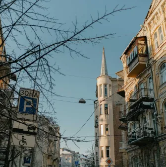 Building with a turret and street signs against a blue sky in Kyiv
