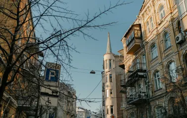 Building with a turret and street signs against a blue sky in Kyiv