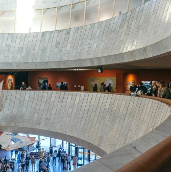 Ukrainskyi Dim in Kyiv - curved white marble balconies overlooking the art exhibition hall filled with people