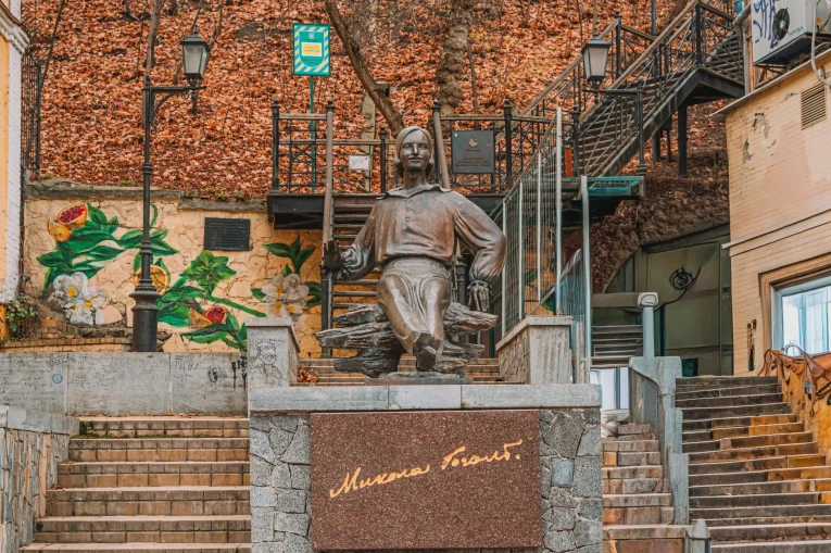 Monument to Mykola Hohol in Kyiv - bronze seated statue on a stone pedestal