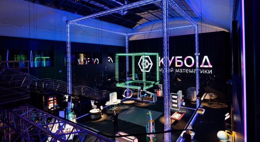 Museum of Mathematics Kuboid in Kyiv - grand museum atrium illuminated by blue neon structures featuring the glowing "Kuboid" logo and various science exhibits