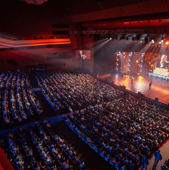 Palats Ukraina in Kyiv - high angle view of the auditorium filled with spectators watching a concert in warm stage lighting