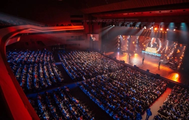 Palats Ukraina in Kyiv - high angle view of the auditorium filled with spectators watching a concert in warm stage lighting