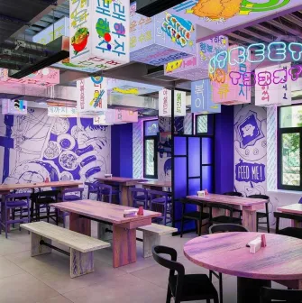 Street Kim - narrow dining space featuring small tables and wooden benches along the wall