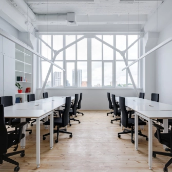 Workspace at Kooperativ with a large window and black office chairs
