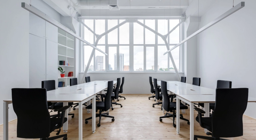 Workspace at Kooperativ with a large window and black office chairs