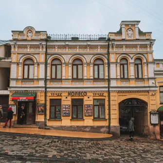 Koleso Theater in Kyiv - full view of historic yellow building on cobbled street