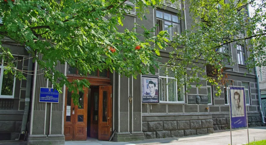 Muzei Tychyny in Kyiv - exterior entrance to the museum apartment located in a historic grey building with a large portrait of the poet displayed outside