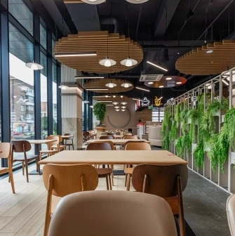 Restaurant Puzata Hata - dining area with wooden tables, vertical gardens, and floor-to-ceiling windows
