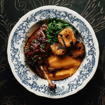 Restaurant Ulyublenyi Diadia - duck leg confit with purée and greens on a decorative plate