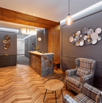 Elegant reception hall of Hotel Classic with a wooden floor and checkered armchairs