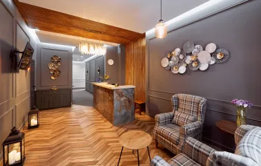 Elegant reception hall of Hotel Classic with a wooden floor and checkered armchairs