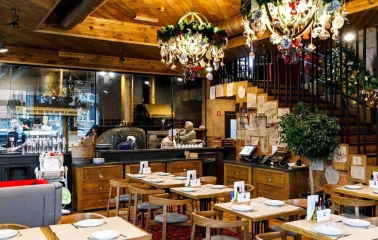 Restaurant Mama Manana - interior with dining tables and a pizza oven