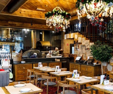 Restaurant Mama Manana - interior with dining tables and a pizza oven
