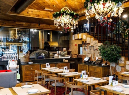 Restaurant Mama Manana - interior with dining tables and a pizza oven