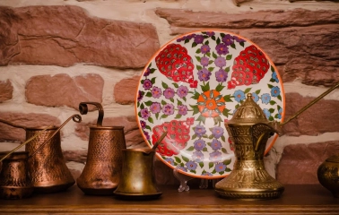 Sofra in Kyiv - decor composition with copper coffee pots and painted ceramic plate