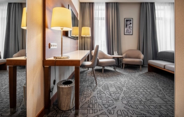 City Hotel in Kyiv - room interior featuring work desk, mirror and two grey armchairs