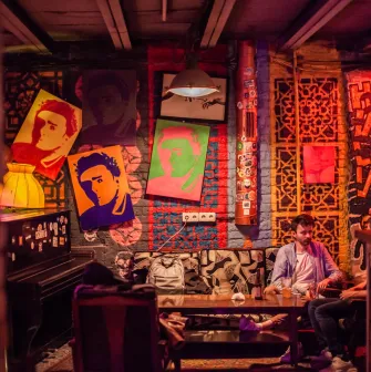 Interior of the "Hvlv" bar in Podil, Kyiv, featuring paintings on the walls