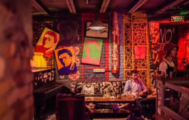 Interior of the "Hvlv" bar in Podil, Kyiv, featuring paintings on the walls