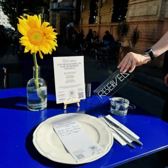 Restaurant Zigzag - outdoor table with a sunflower a reserved sign and cutlery