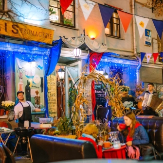 Très Français - outdoor terrace with chef, musician and decorated facade