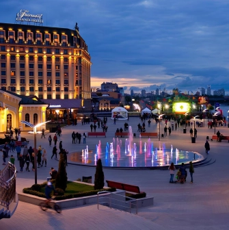 Poshtova Square in Kyiv - evening view with illuminated fountains and walking people