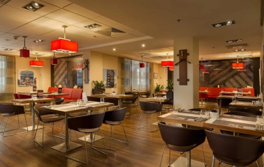 Ibis Kyiv City Center in Kyiv - dining hall with wooden tables and red lamps