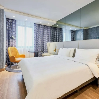 Spacious modern room at the Radisson Blu Hotel in the center of Kyiv with a double bed and a seating area