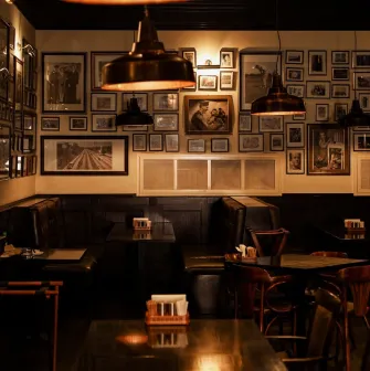 Goodman Steak House - dining tables set with plates, glassware, and white linens for guests