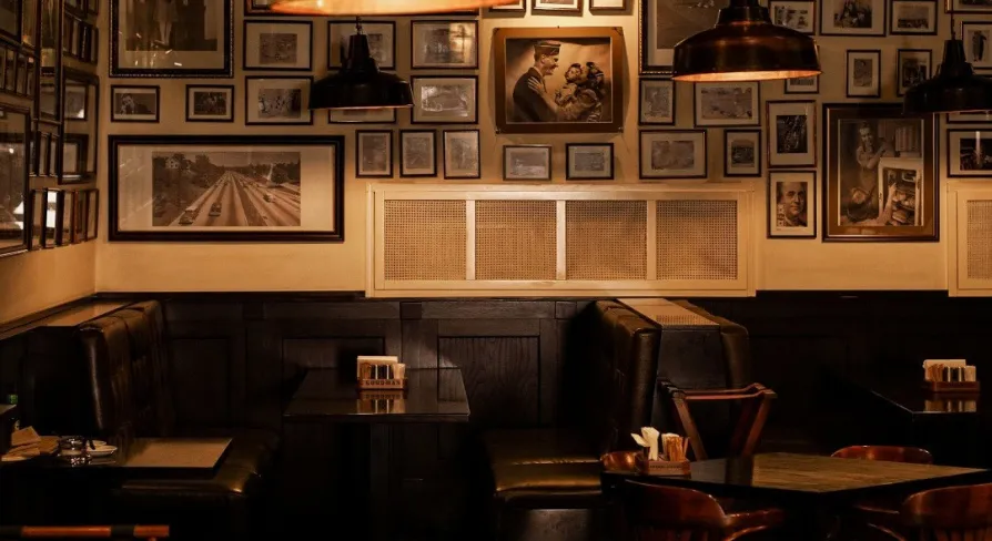 Goodman Steak House - dining tables set with plates, glassware, and white linens for guests