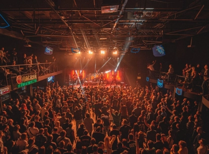 Atlas in Kyiv - high angle view of the packed concert hall with balconies and stage lights beaming through the smoke