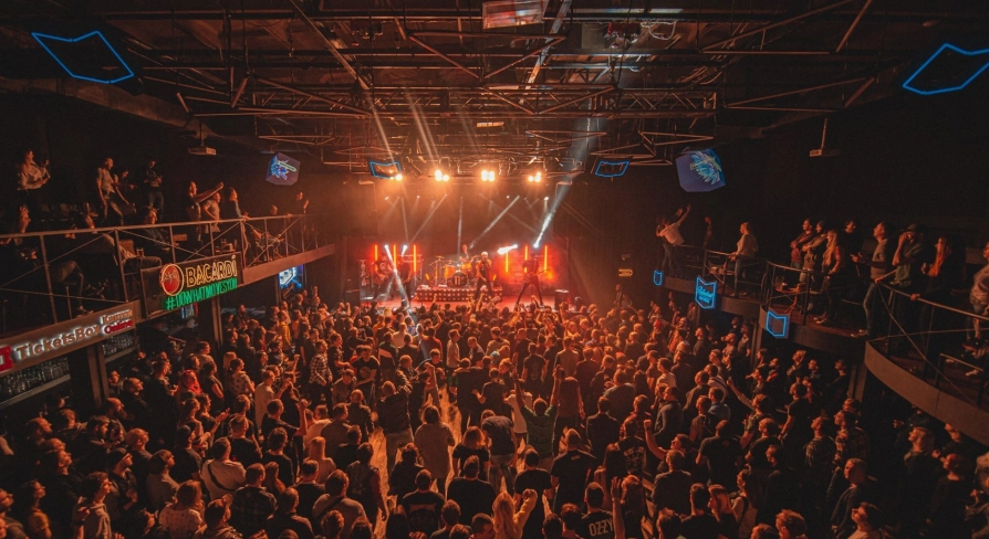 Atlas in Kyiv - high angle view of the packed concert hall with balconies and stage lights beaming through the smoke