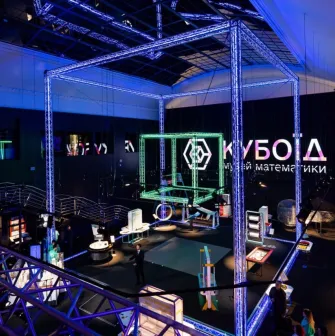 Museum of Mathematics Kuboid in Kyiv - grand museum atrium illuminated by blue neon structures featuring the glowing "Kuboid" logo and various science exhibits