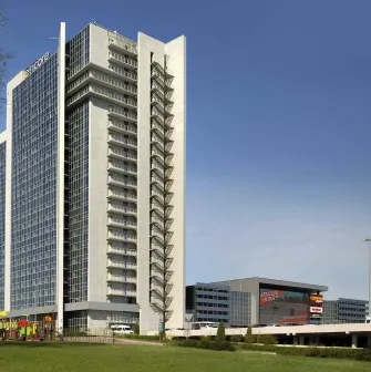 Exterior view of the high-rise hotel building with parking area
