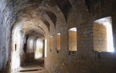Kyiv Fortress in Kyiv - long curved brick tunnel with light streaming through loopholes