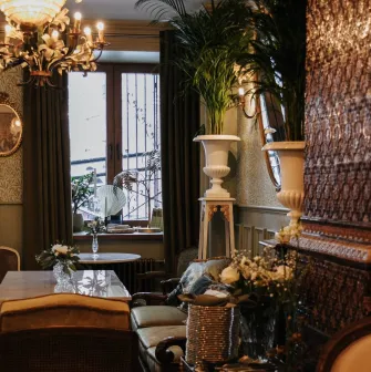 Etre Sofie - small, intimate dining area next to a window with decorative plants