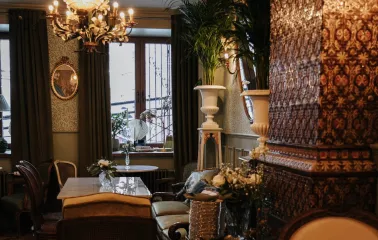 Etre Sofie - small, intimate dining area next to a window with decorative plants