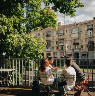 Octo Tower - outdoor terrace with people sitting at table under tree